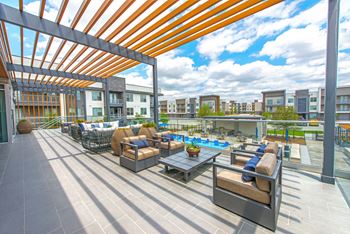 A patio with a table and chairs under a roof.